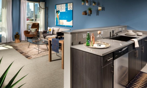 a kitchen with a bar and view of a living room