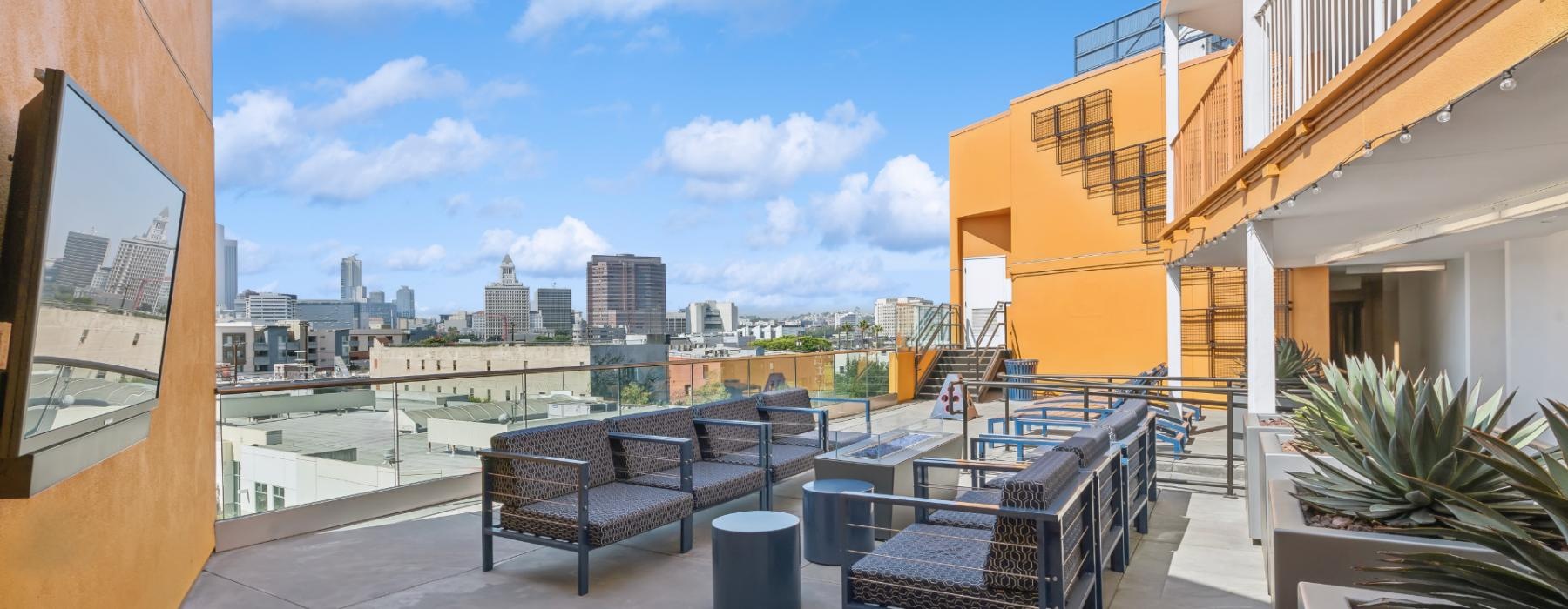a patio with chairs and tables on it with a city in the background